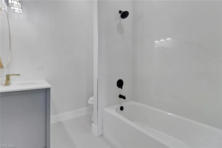 Full bathroom featuring toilet, vanity, and tiled shower / bath
