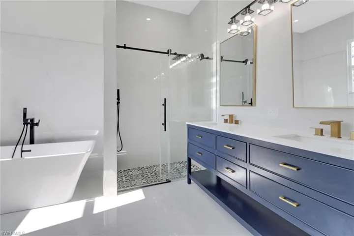 Bathroom featuring vanity and independent shower and bath