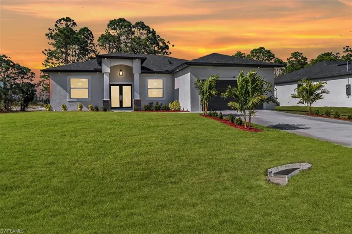 View of front of house featuring a garage and a lawn