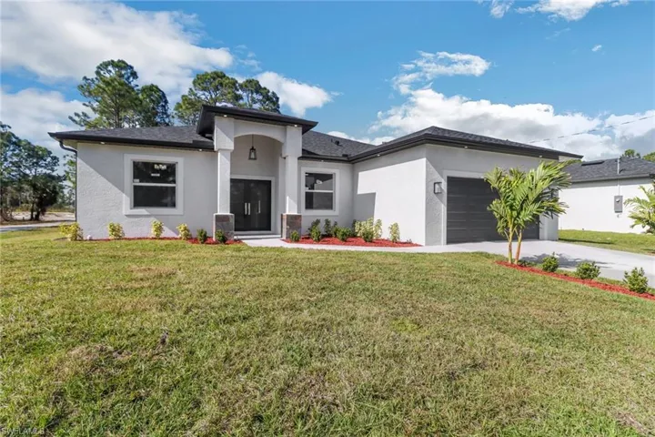 View of front of house with a garage and a front yard