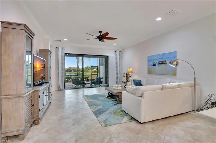 Living area featuring light tile patterned floors, ornamental molding, ceiling fan, and recessed lighting