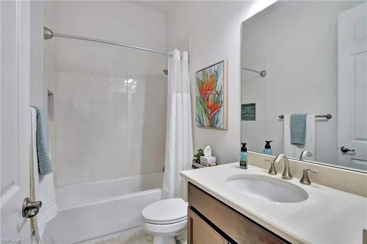 Bathroom with vanity and shower / tub combo with curtain
