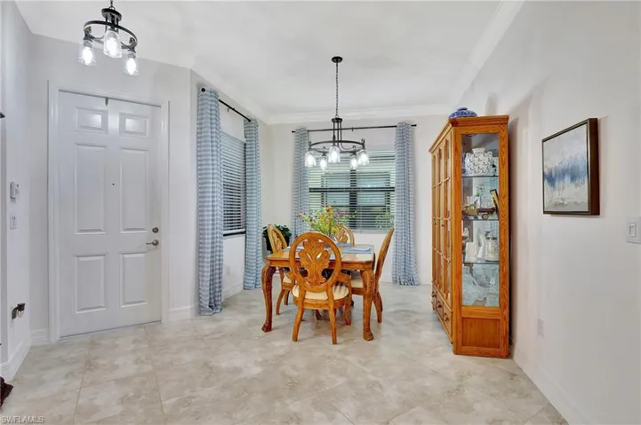 Dining space with a chandelier and crown molding