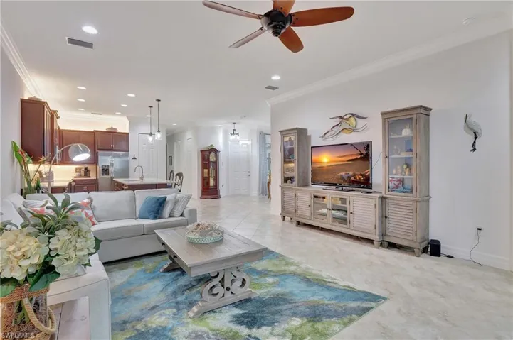 Living room featuring crown molding, a ceiling fan, recessed lighting, and light tile patterned flooring