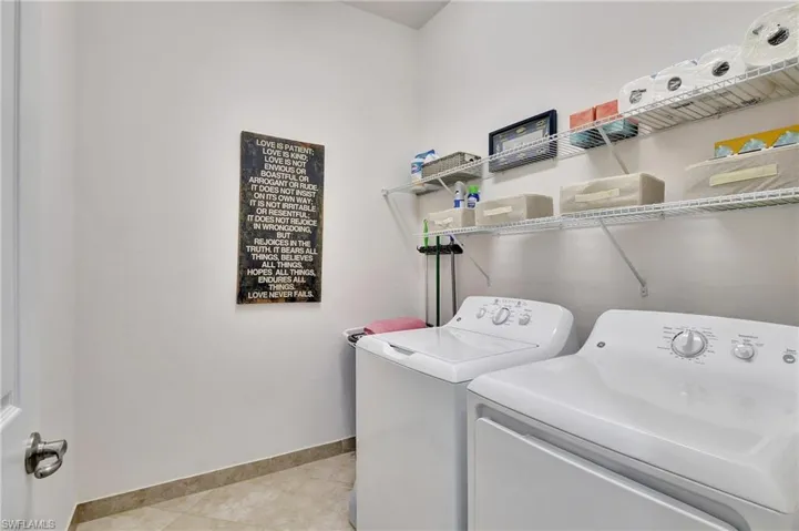 Laundry room with separate washer and dryer and light tile patterned floors