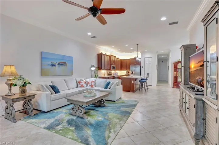 Living room featuring ornamental molding, ceiling fan, light tile patterned floors, and recessed lighting