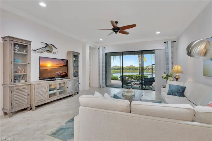 Living area with ornamental molding, light tile patterned flooring, a ceiling fan, and recessed lighting