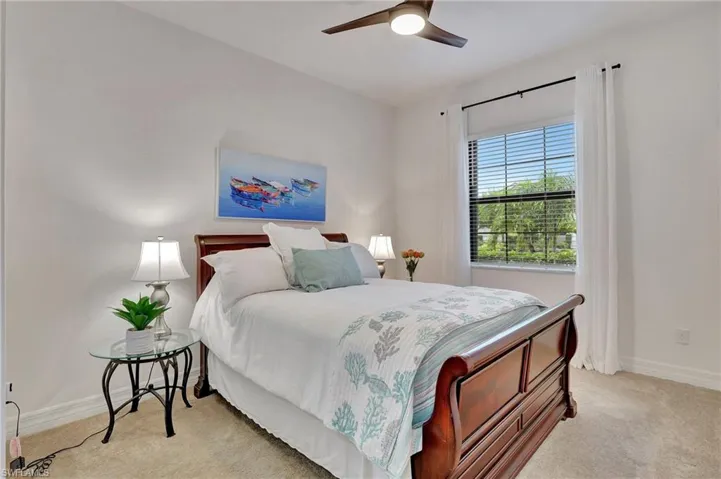 Bedroom with ceiling fan and light carpet