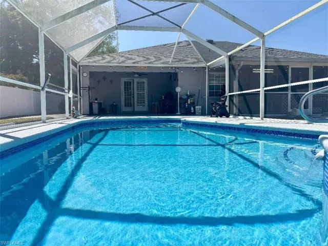 Pool with glass enclosure, ceiling fan, and a patio