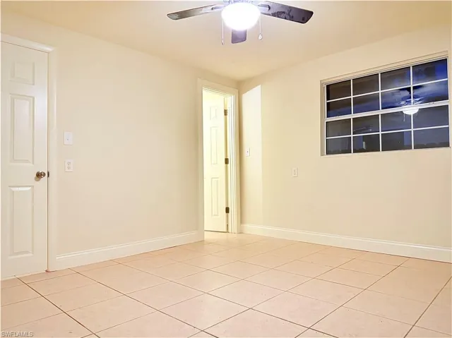 Unfurnished room featuring light tile patterned floors and a ceiling fan