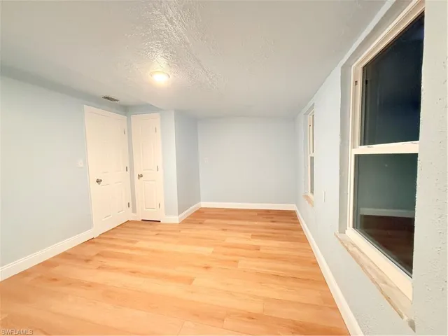 Spare room featuring light wood-style flooring and a textured ceiling