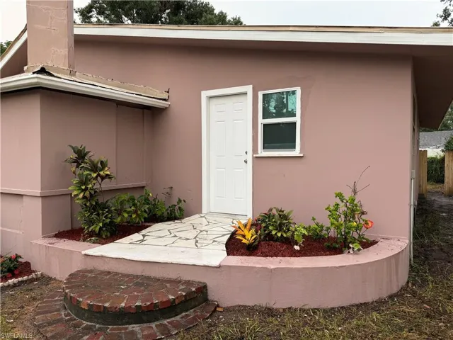 Doorway to property featuring stucco siding