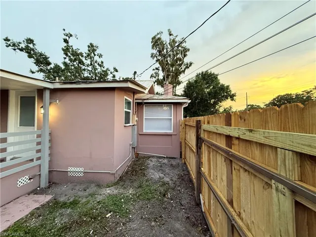 View of side of property with a fenced backyard and stucco siding