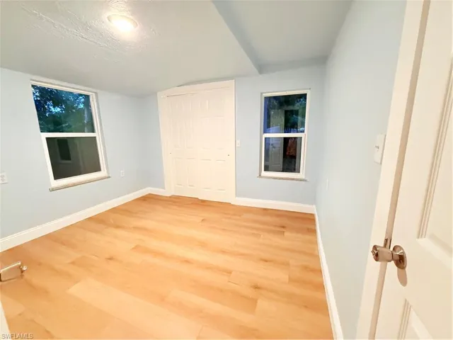 Unfurnished bedroom featuring light wood-style floors, a textured ceiling, and a closet