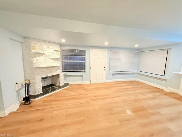 Unfurnished living room with light wood-style floors, a stone fireplace, and recessed lighting