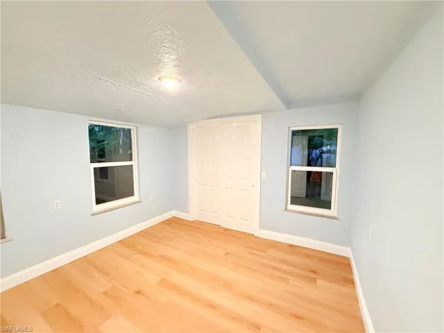Unfurnished bedroom with light wood-style floors, a textured ceiling, and a closet