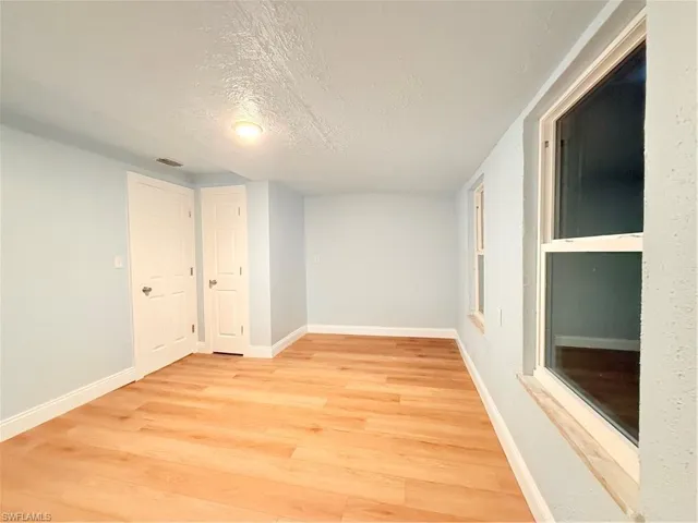 Unfurnished room featuring a textured ceiling and light wood-style flooring