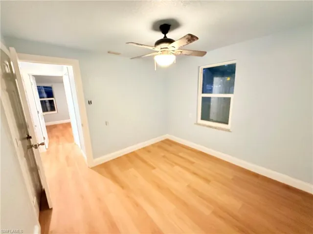 Empty room with light wood-style flooring and ceiling fan