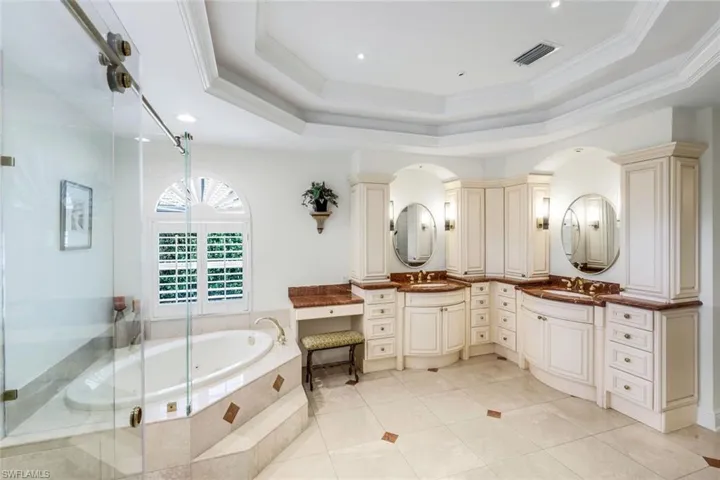 Bathroom with vanity, a bath, crown molding, light tile patterned flooring, and a shower stall