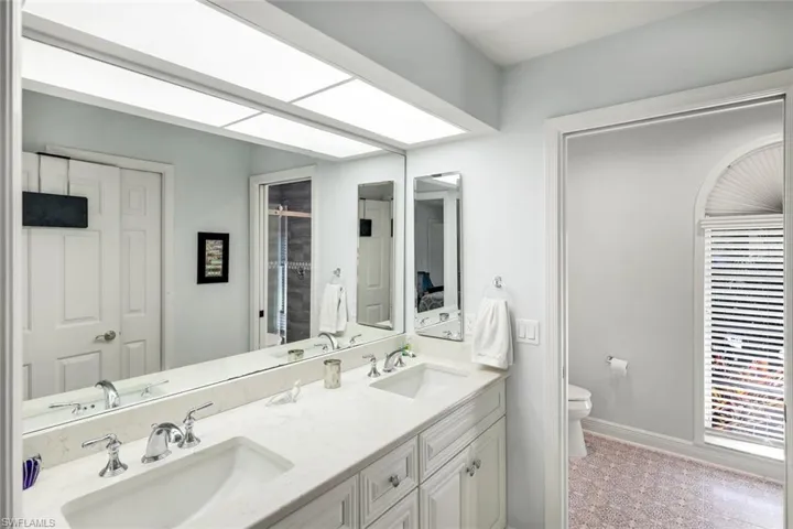 Bathroom featuring double vanity and a stall shower