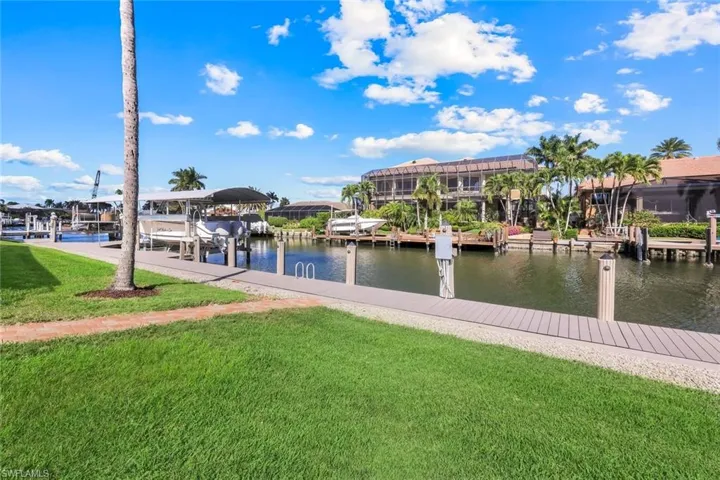 Dock area featuring a lawn, a water view, and boat lift