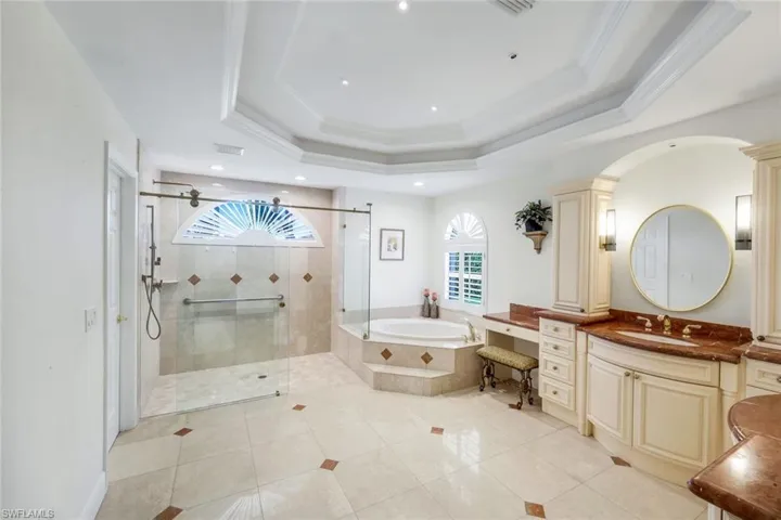 Bathroom with vanity, a garden tub, light tile patterned floors, crown molding, and a stall shower