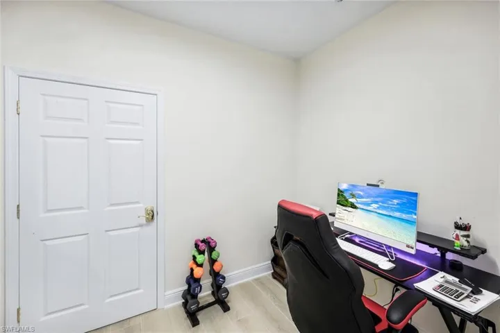 Home office featuring light wood-type flooring and baseboards