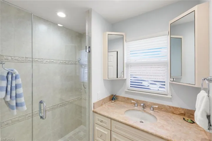 Full bathroom with vanity, a shower stall, and recessed lighting