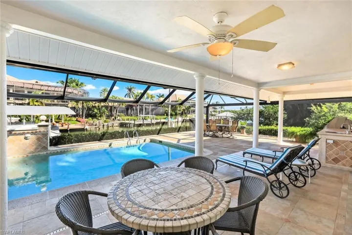 Outdoor pool with outdoor dining space, a patio area, a lanai, a sunroom, and a water view
