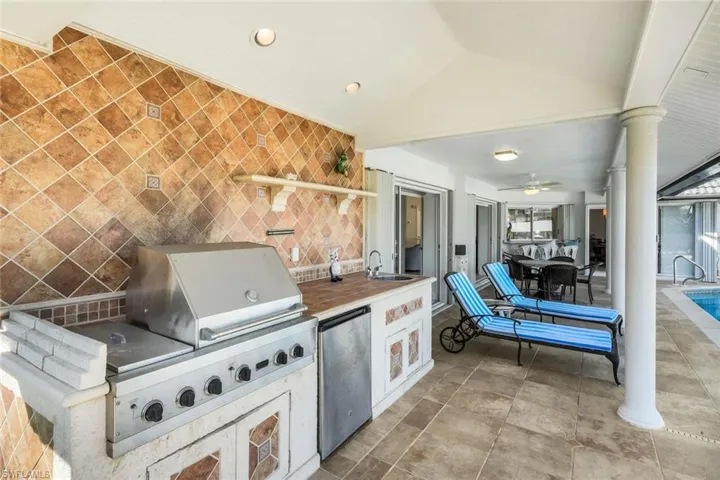 View of patio with an outdoor kitchen and ceiling fan