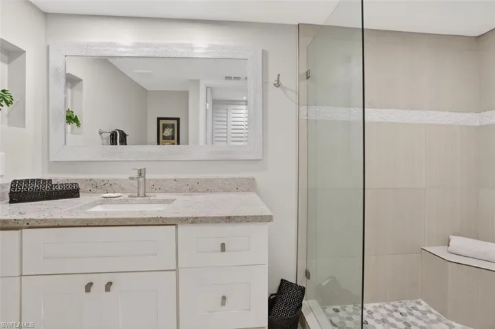 Primary bath with large walk-in shower and extended vanity with granite counter-top