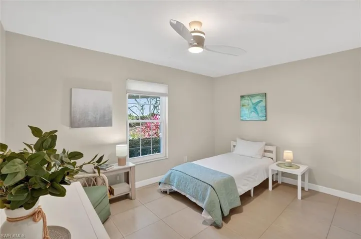 Bedroom with ceiling fan and light tile patterned floors