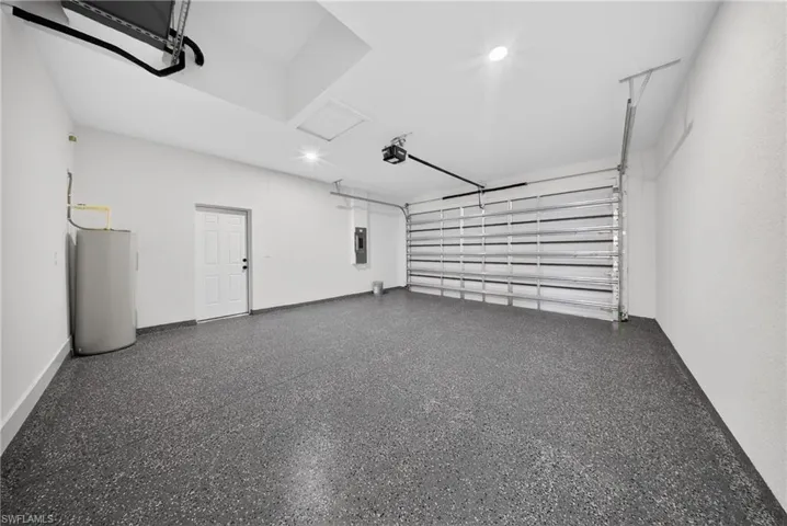 Garage featuring water heater and electric panel