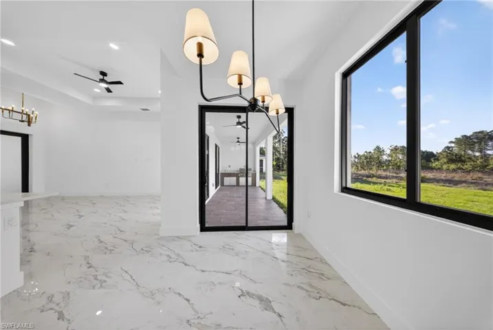 Unfurnished dining area featuring hanging lights, ceiling fan, and light marble finish floors