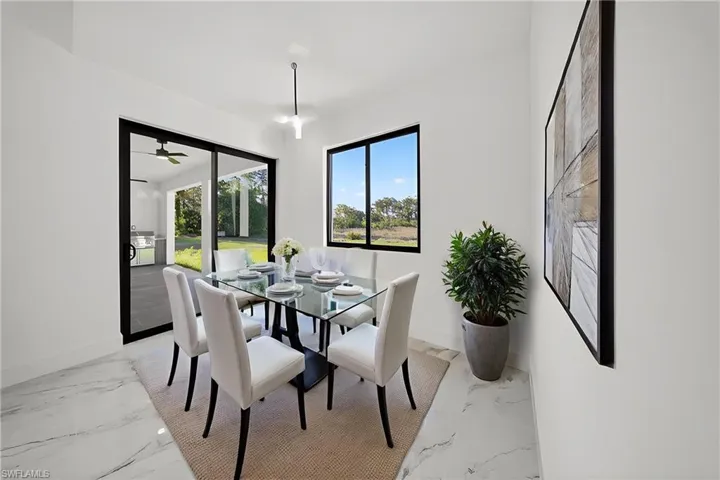 Dining room with light marble finish floors and baseboards