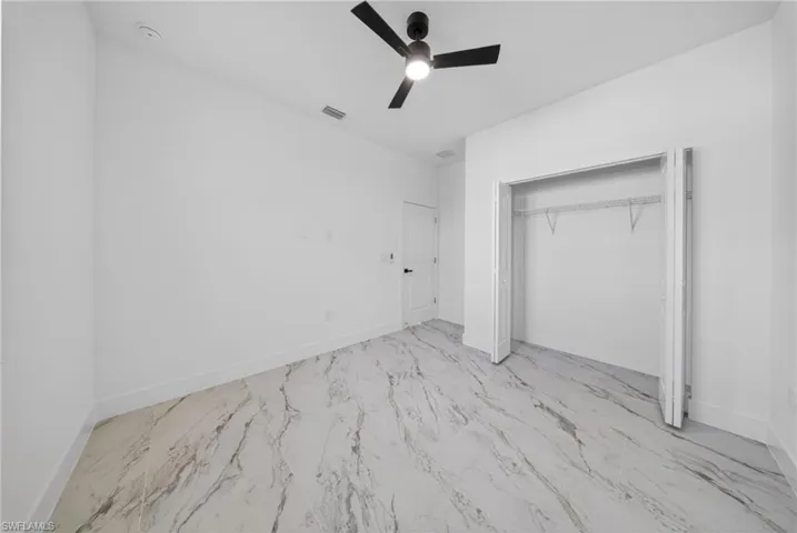 Unfurnished bedroom featuring ceiling fan and a closet
