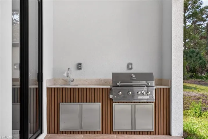 View of patio featuring exterior kitchen and a sink