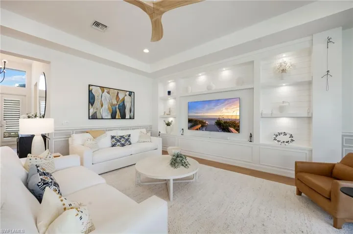 The custom wall feature in the great room feels grounded and inviting. Impact sliders lead out to the outdoor living area - this is seamless indoor/outdoor living!