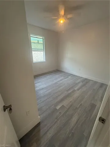 Spare room with hardwood / wood-style floors and ceiling fan