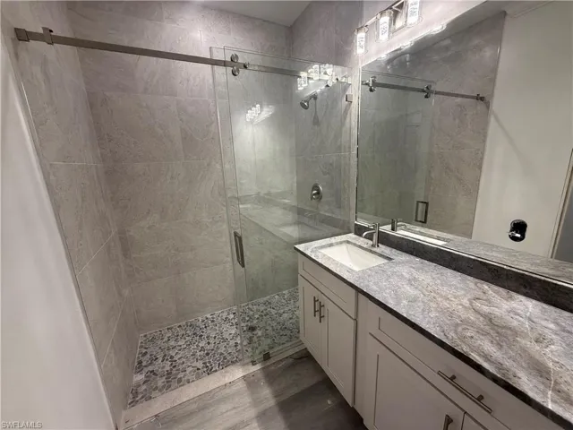 Bathroom featuring vanity, hardwood / wood-style floors, and walk in shower