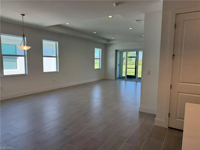 Great room living area with tray ceiling and casual dining space