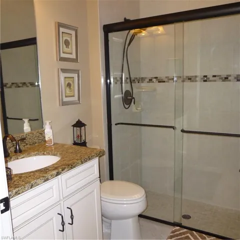 Bathroom with vanity, walk in shower, and toilet