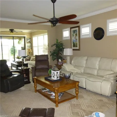 Living room featuring ornamental molding and ceiling fan