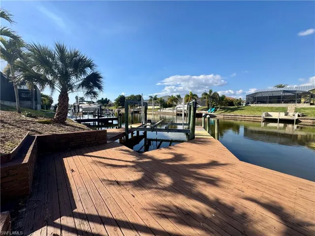 Dock area featuring boat lift and a water view