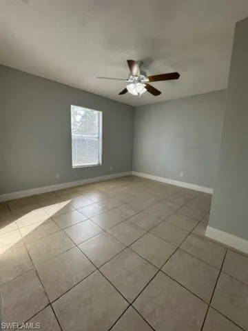 Spare room with a textured ceiling, a ceiling fan, and light tile patterned floors