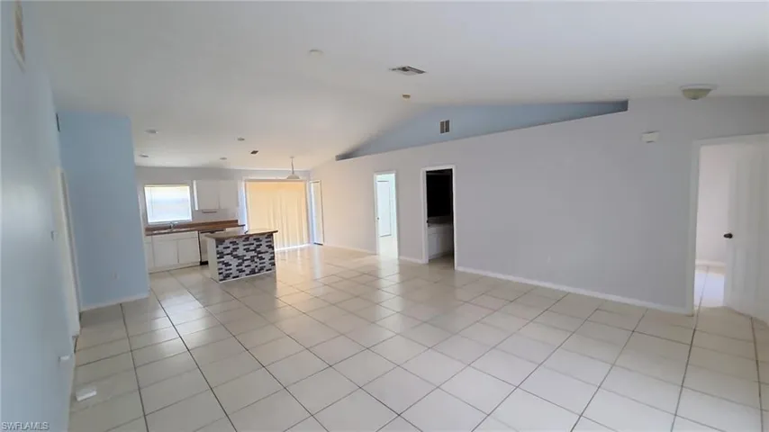 Expansive living area with neutral tile flooring throughout