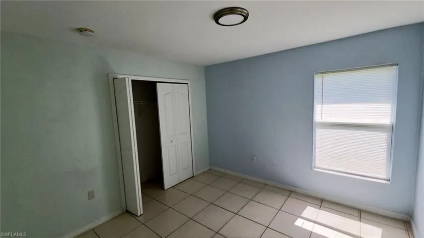 Interior room featuring light blue walls and neutral tile flooring