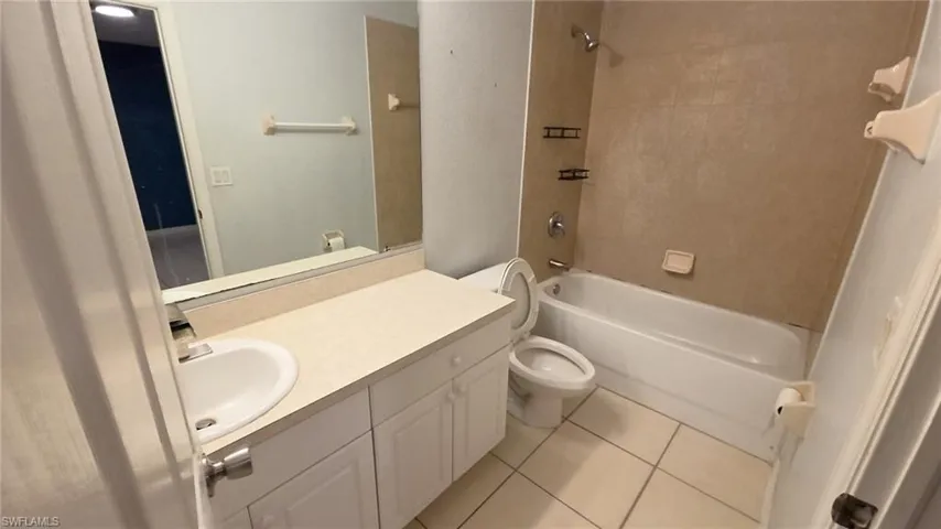 Bathroom featuring a white vanity with integrated sink, coordinating countertop, and a large wall-mounted mirror