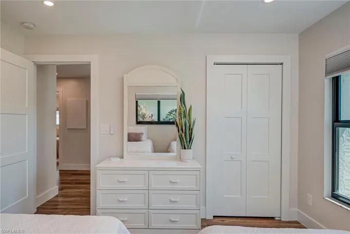 Bedroom featuring recessed lighting, dark wood-style floors, a closet, and multiple windows