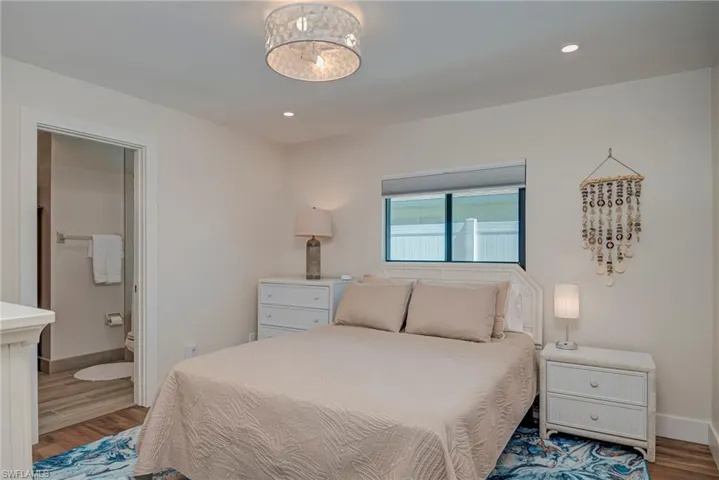 Bedroom featuring wood finished floors, recessed lighting, and ensuite bathroom